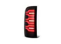 A vertical, rectangular car taillight named "14-18 Sierra 1500/2500/3500HD Luxx LED Tail Lights Alpha-Black w/Activation Light & Seq Signal" from AlphaRex USA features a black frame with red LED lights arranged in curvy, horizontal lines. The light assembly, displayed against a plain white background, emphasizes the design and illumination pattern.