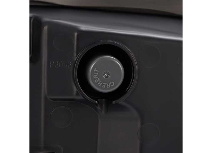 Close-up image of a black plastic surface with a circular indentation. The indentation features a raised button or knob labeled "CHEKRIT." The surface appears to be part of a larger mechanical or electronic device, exhibiting precision craftsmanship reminiscent of the AlphaRex USA RAM LUXX LED Tail Lights Alpha-Black with Sequential Signal Lights for the 19-22 Model.