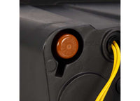 Close-up of a mechanical device featuring a small circular orange button labeled "DENKO," situated in a recessed slot. Adjacent to it are yellow cables extending from the device, along with embossed text "P3046" on its dark casing, offering enhanced visibility akin to the AlphaRex USA RAM 1500/2500/3500 2002-2005/2003-2005 Nova-Series LED Projector Headlights - Alpha Black.