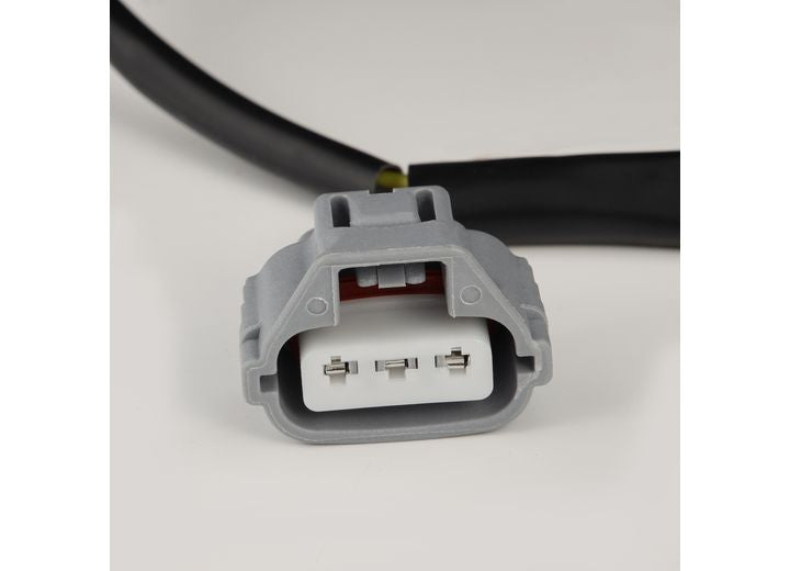 Close-up of a gray electrical connector attached to a black cable. The connector, essential for the Tundra 14-21 LED Projector Headlights with Sequential Signal & DRL from AlphaRex USA, features three metal prongs inside and is designed for specific plug compatibility. It is situated on a plain, light-colored surface.