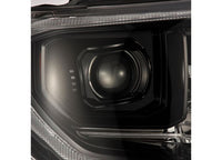 Close-up view of the Tundra 14-21 LED Projector Headlights with Sequential Signal & DRL by AlphaRex USA, featuring a sleek and modern design. The black and silver casing encases the circular LED projector headlights, reflecting a sophisticated and symmetrical pattern. The illuminated headlight showcases its contemporary and stylish aesthetic with advanced technology.