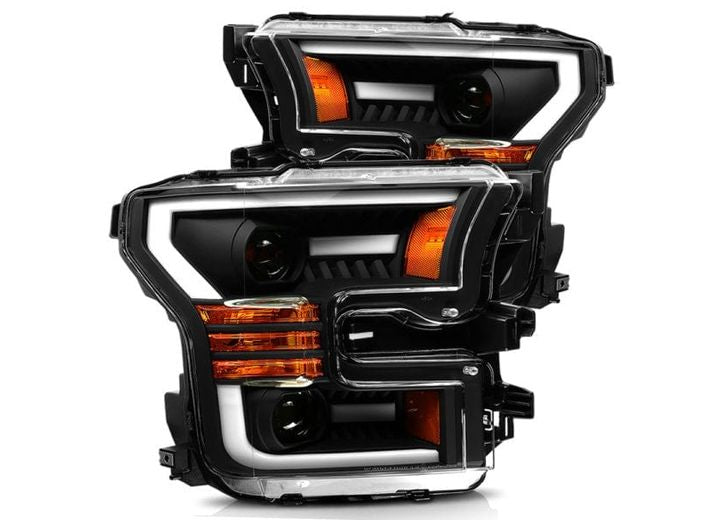 Introducing the AlphaRex USA 15-17 F150/17-20 F150 RAPTOR PRO-SERIES PROJECTOR HEADLIGHTS in Black, featuring modern angular designs, orange turn signal lights, and clear outer lenses. These headlights boast a combination of white and orange LED lights and black internal housings, offering a truly futuristic look.