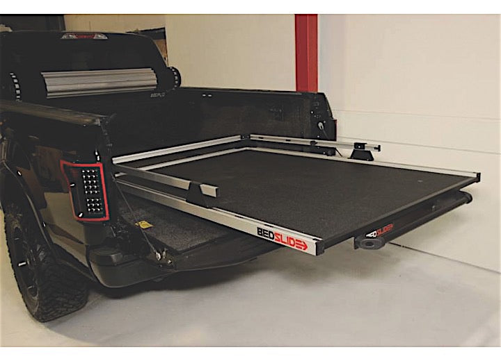 A black pickup truck with its tailgate down, showcasing a Bedslide BEDSLIDE 1500 CONTRACTOR 78IN X 48IN cargo management system. The sliding platform is extended out from the truck bed, revealing a sturdy, flat surface designed for easy loading and unloading of cargo.