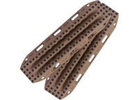 A pair of MAXTRAX XTREME DESERT TAN RECOVERY BOARDS from MAXTRAX are overlapped in an X-shape. These boards feature multiple rows of raised black traction nodules and have several oval-shaped handles and mounting holes along the edges for easy carrying and secure placement during your off-road adventures.